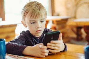 Young boy plays games on smart phone | Child dental health