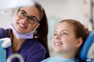 Child smiling in chair and orthodontic appointment