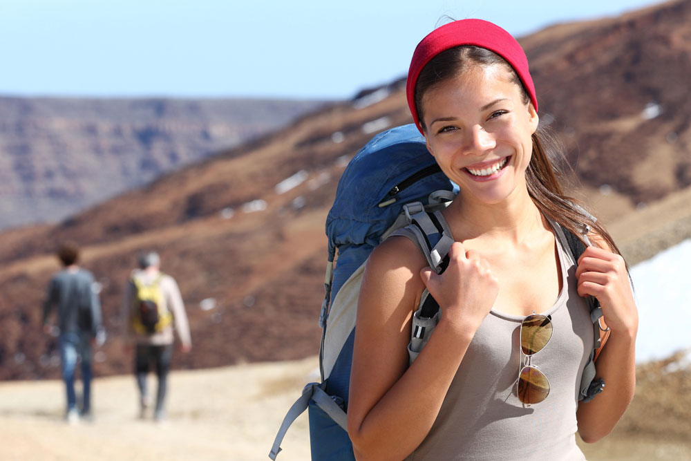 Smiling and healthy young woman on hike