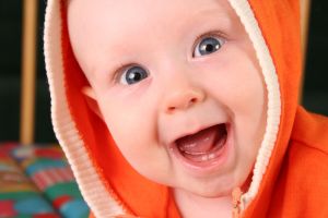 Extremely happy baby smiling with baby teeth