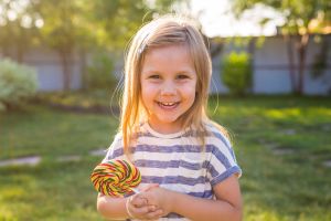 Smiling young girl with a lollipop